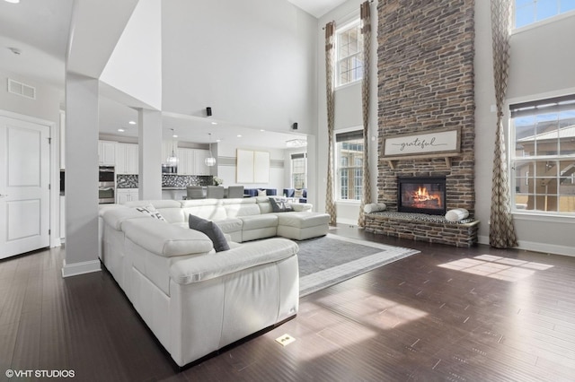 living room featuring visible vents, a high ceiling, and dark wood finished floors