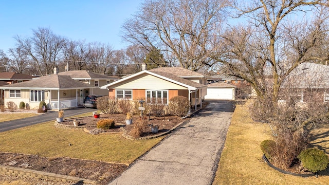 single story home with a porch, an outdoor structure, a garage, and a front lawn