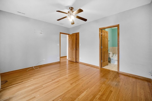 empty room with visible vents, baseboards, a ceiling fan, and light wood finished floors