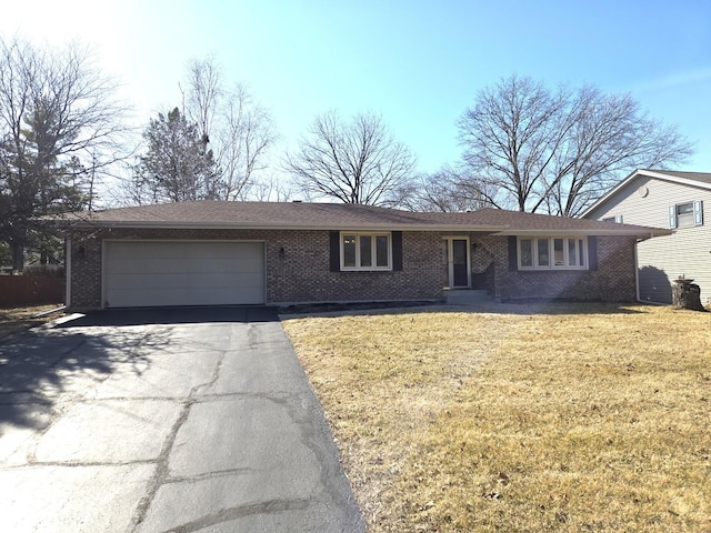 ranch-style house featuring aphalt driveway, brick siding, a garage, and a front yard