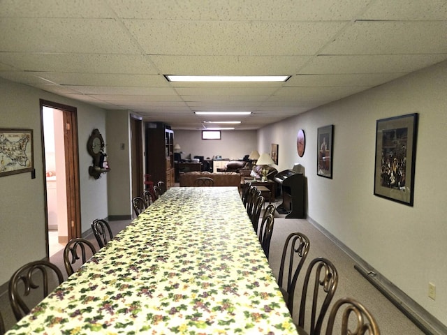 dining room featuring a drop ceiling and baseboards