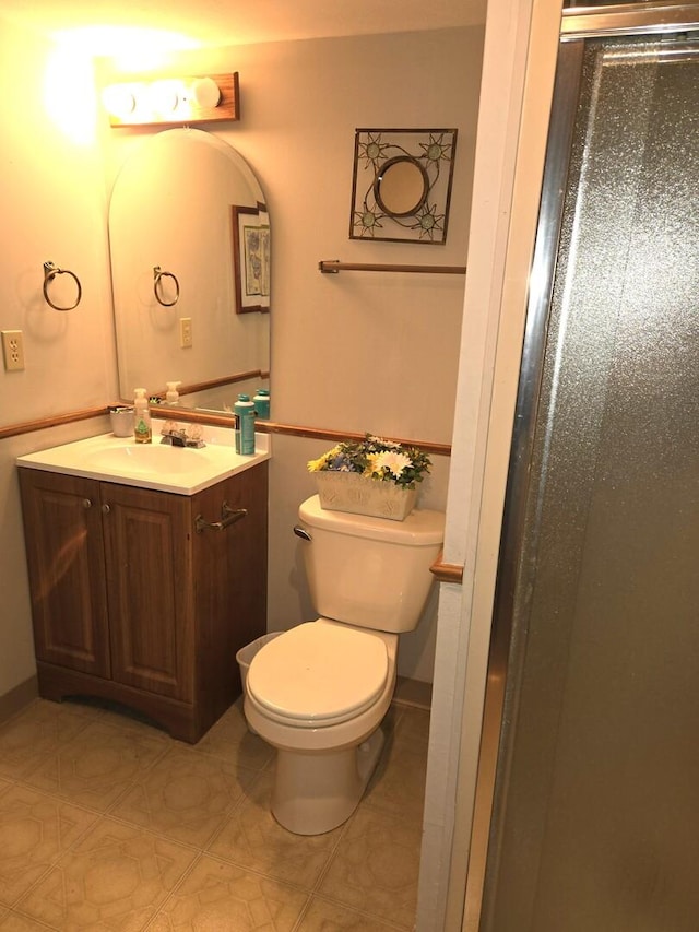 bathroom with vanity, toilet, and a stall shower