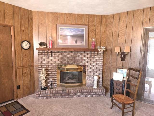 carpeted living area featuring wooden walls and a fireplace