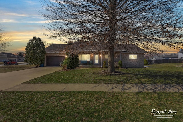 view of front of house with fence, concrete driveway, a garage, a lawn, and brick siding