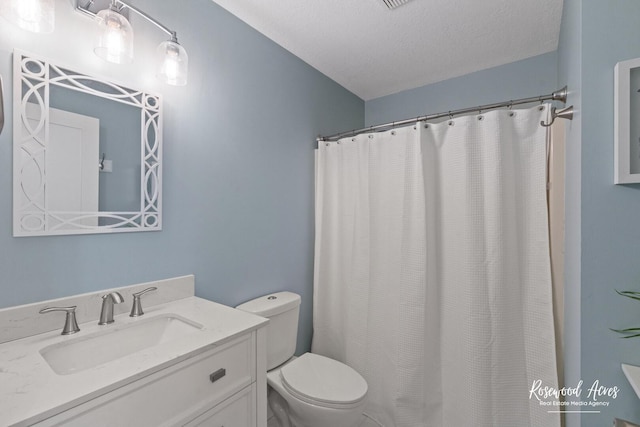 bathroom featuring a shower with shower curtain, toilet, vanity, and a textured ceiling