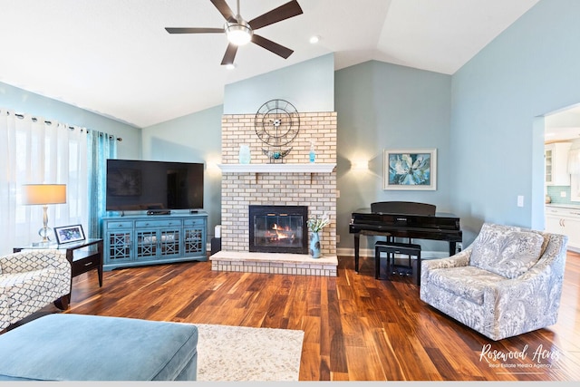 living room featuring a fireplace, a ceiling fan, lofted ceiling, and wood finished floors