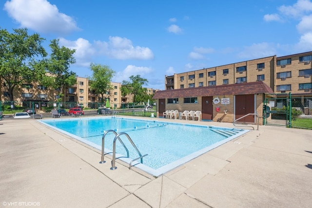 community pool with fence and a patio