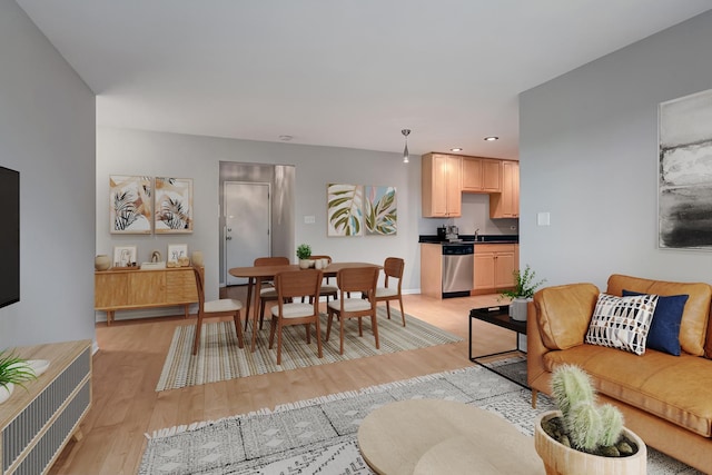 living room with light wood-style floors, recessed lighting, and baseboards