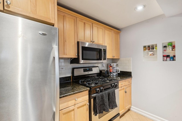 kitchen featuring tasteful backsplash, dark stone countertops, light brown cabinets, and stainless steel appliances