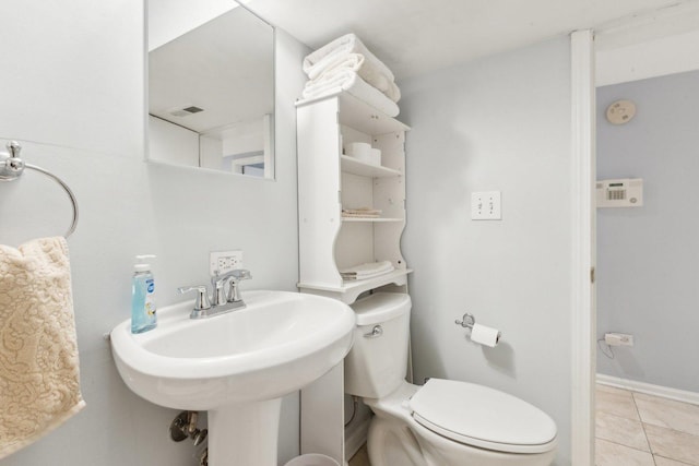 bathroom featuring tile patterned floors, baseboards, toilet, and a sink