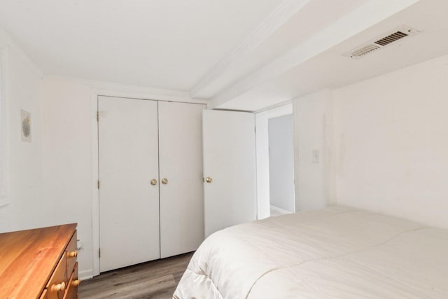 bedroom with visible vents, a closet, and light wood finished floors