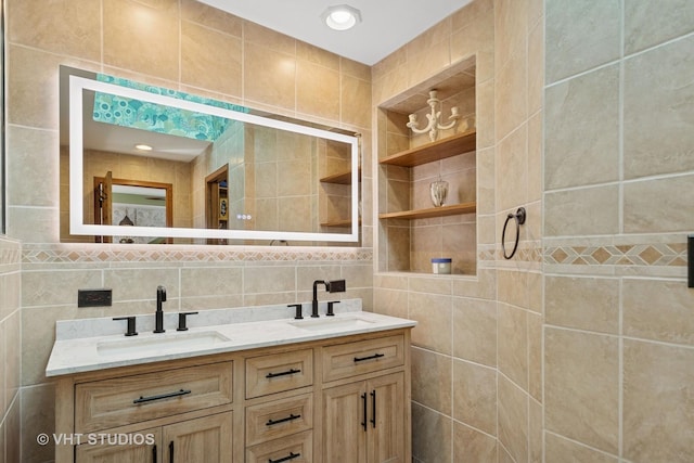 full bath featuring double vanity, backsplash, tile walls, and a sink