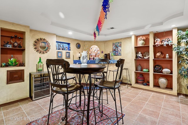 dining space featuring built in features, visible vents, a tray ceiling, tile patterned flooring, and wine cooler