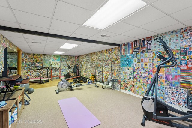 workout area featuring visible vents, wallpapered walls, carpet, and a drop ceiling