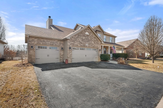 view of front of home featuring aphalt driveway, brick siding, and a garage