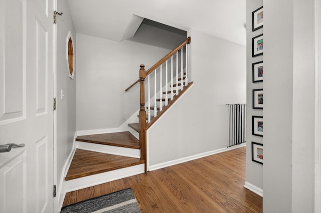 staircase with wood finished floors and baseboards