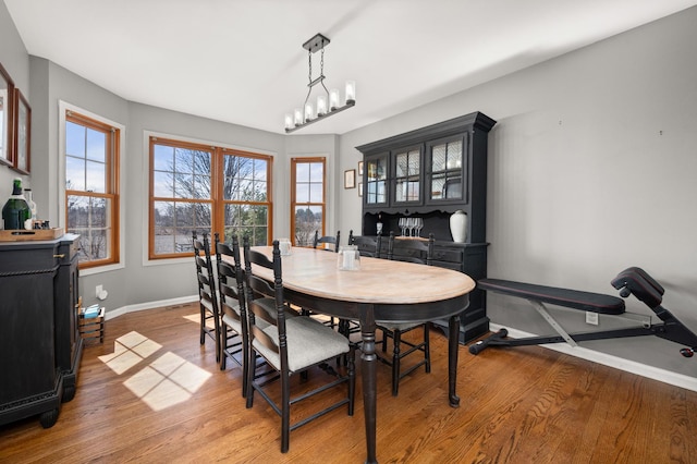 dining space featuring baseboards, plenty of natural light, and light wood-style floors