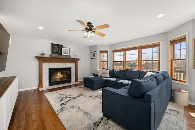 living room with a fireplace with flush hearth, recessed lighting, a ceiling fan, and dark wood-style flooring