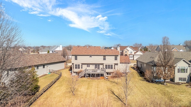 back of house featuring a yard, a residential view, and a wooden deck