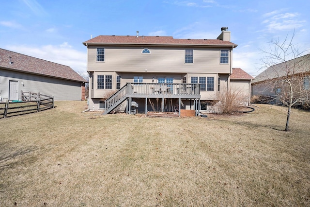 back of house with fence, stairway, a yard, a wooden deck, and a chimney