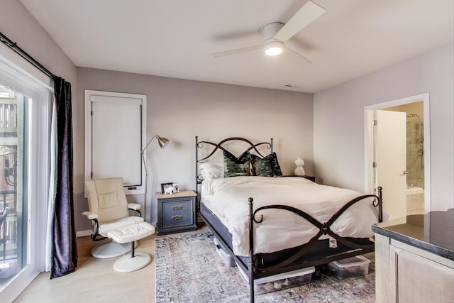 bedroom featuring multiple windows, ensuite bathroom, ceiling fan, and wood finished floors