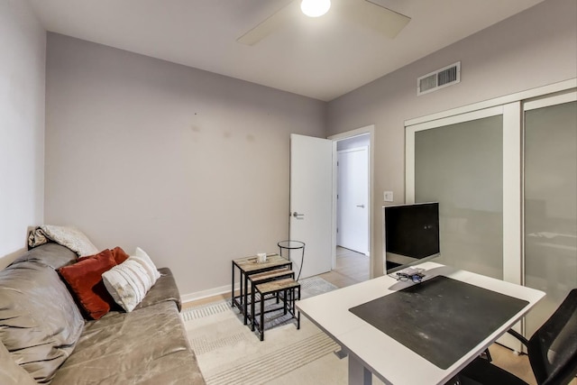 office area featuring a ceiling fan, visible vents, and baseboards