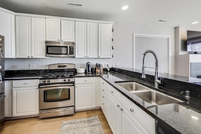 kitchen with white cabinets, visible vents, appliances with stainless steel finishes, and a sink