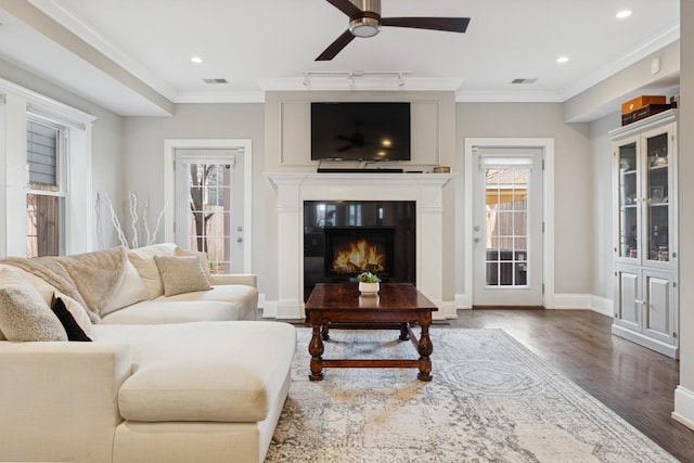 living room featuring visible vents, wood finished floors, and ornamental molding