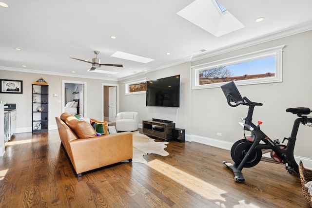 living area with a skylight, wood finished floors, and ornamental molding