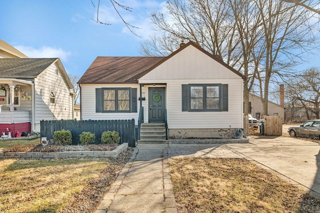 bungalow-style house featuring a shingled roof and fence