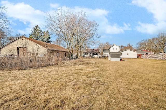 view of yard with a storage unit, an outdoor structure, and fence