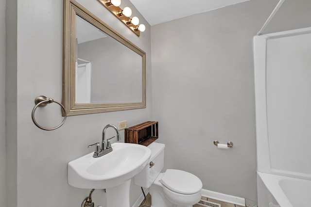 bathroom with a sink, visible vents, baseboards, and toilet