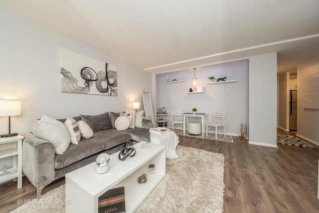 living area with baseboards and wood finished floors