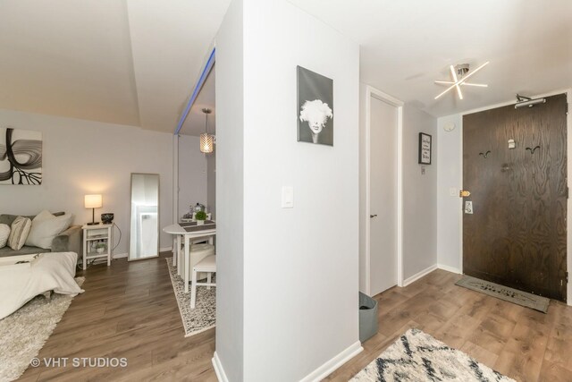 foyer entrance with baseboards and wood finished floors