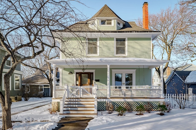 traditional style home featuring french doors, a porch, and a chimney