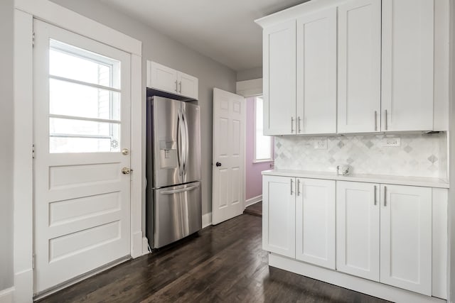 kitchen with dark wood finished floors, stainless steel fridge with ice dispenser, decorative backsplash, light countertops, and white cabinets