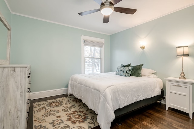 bedroom with dark wood finished floors, ceiling fan, crown molding, and baseboards