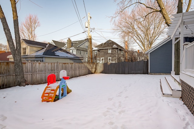 yard layered in snow with a fenced backyard