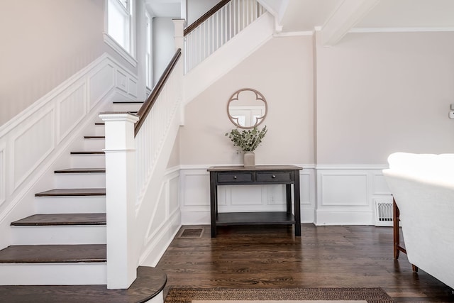 staircase with a decorative wall and wood finished floors