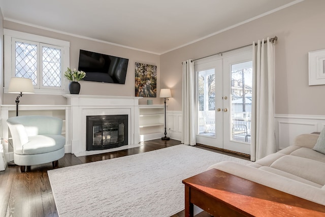 living area featuring french doors, plenty of natural light, dark wood-type flooring, and crown molding