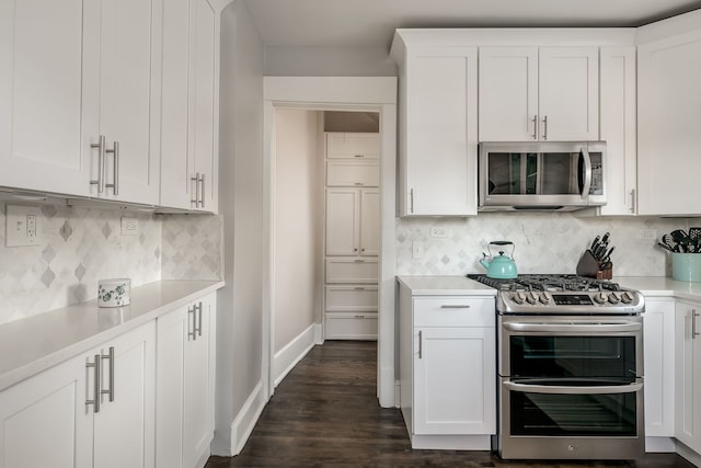 kitchen featuring white cabinetry, stainless steel appliances, light countertops, decorative backsplash, and baseboards