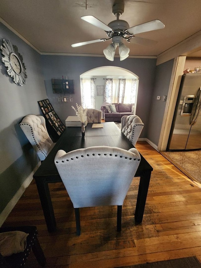 dining space featuring baseboards, a ceiling fan, wood finished floors, and crown molding