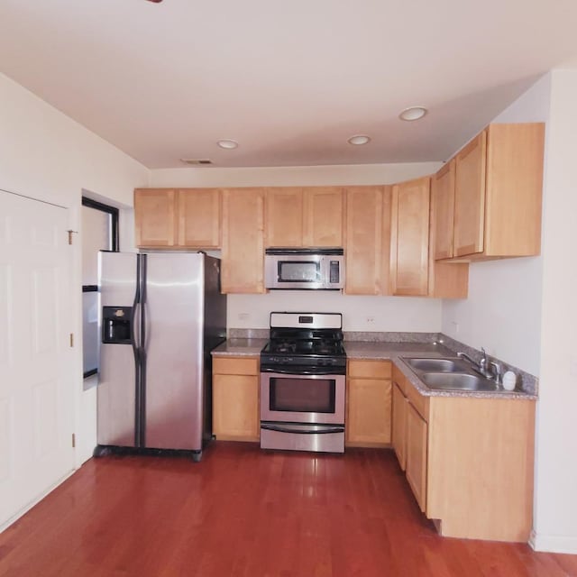 kitchen featuring light brown cabinetry, dark wood finished floors, recessed lighting, stainless steel appliances, and a sink