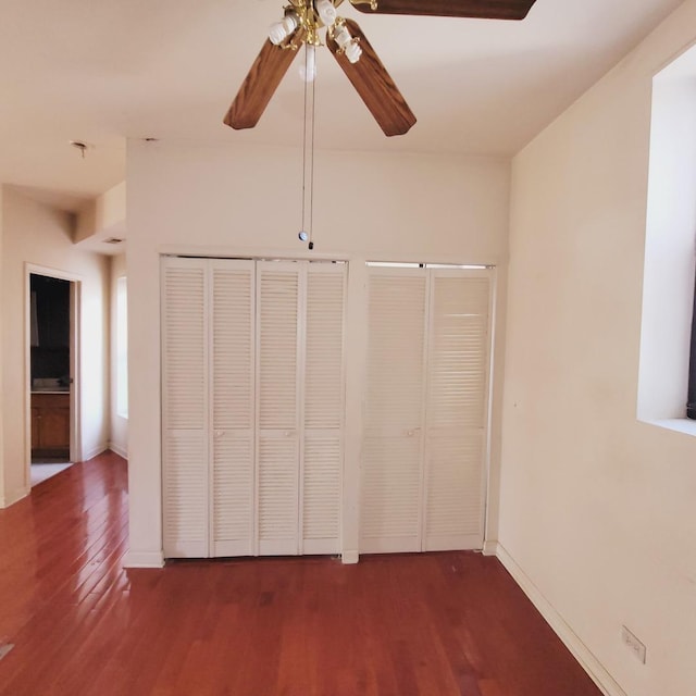 unfurnished bedroom with baseboards, wood finished floors, and a ceiling fan