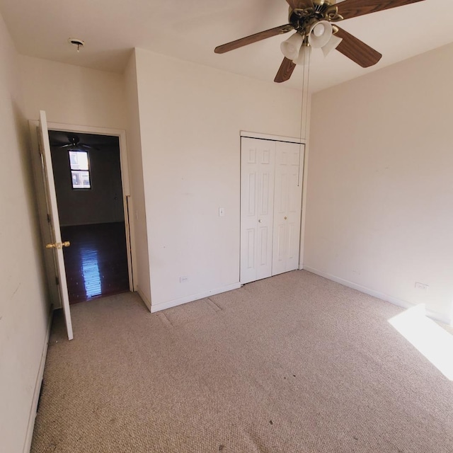 unfurnished bedroom featuring a closet, baseboards, carpet floors, and ceiling fan