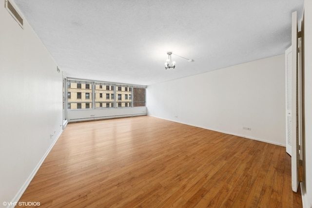 201 E Chestnut St Unit 14E, Chicago, IL 60611 - unfurnished room featuring a chandelier, light wood-type flooring, and baseboards