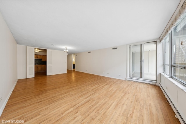 201 E Chestnut St Unit 14E, Chicago, IL 60611 - unfurnished living room with baseboard heating, light wood-type flooring, and baseboards