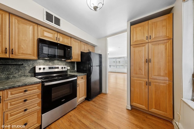 201 E Chestnut St Unit 14E, Chicago, IL 60611 - kitchen with black appliances, decorative backsplash, dark countertops, light wood finished floors, and baseboards