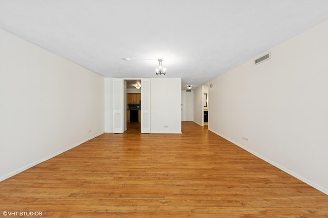 201 E Chestnut St Unit 14E, Chicago, IL 60611 - unfurnished living room featuring light wood finished floors, baseboards, and a chandelier