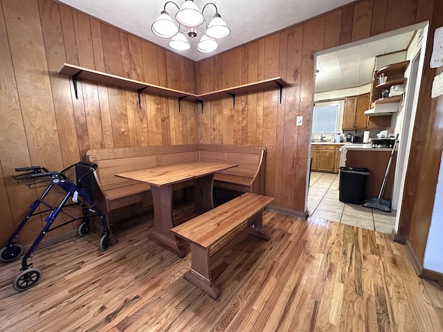 dining area featuring wooden walls and light wood-style flooring